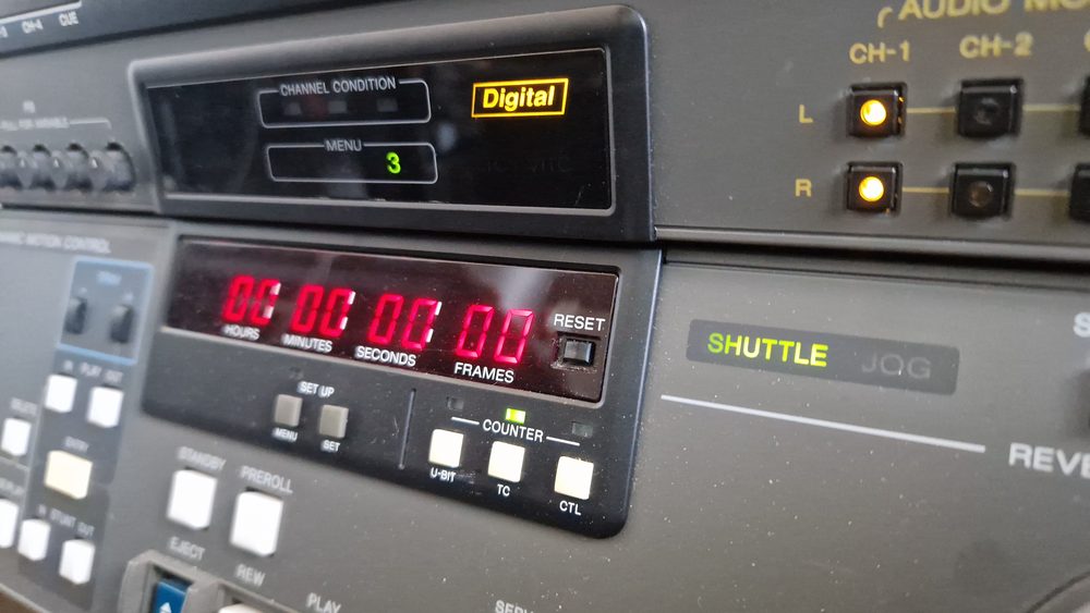 Close-up of a professional tape deck's timecode counter and channel condition display